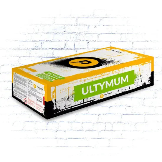 Eine rechteckige Pappschachtel mit der Aufschrift "Pryme Ultymum" der Marke Pryme in gelbem, schwarzem und weißem Design mit Branding und Etiketten an den Seiten steht vor einem weißen Backsteinmauer-Hintergrund.