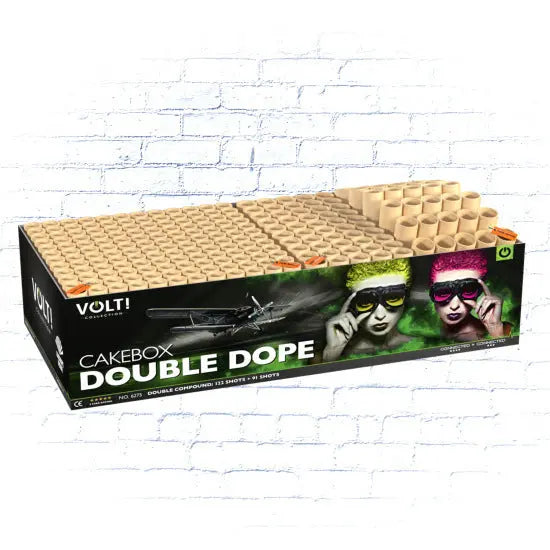 Die VOLT! Double Dope Feuerwerkskuchen von VOLT! kommt in einer schwarzen Box mit lebendigen Grafiken von zwei Menschen in Neon-Perücken und Sonnenbrillen vor einem weißen Backstein-Hintergrund und liefert eine atemberaubende 213-Schuss-Verbund-Display.