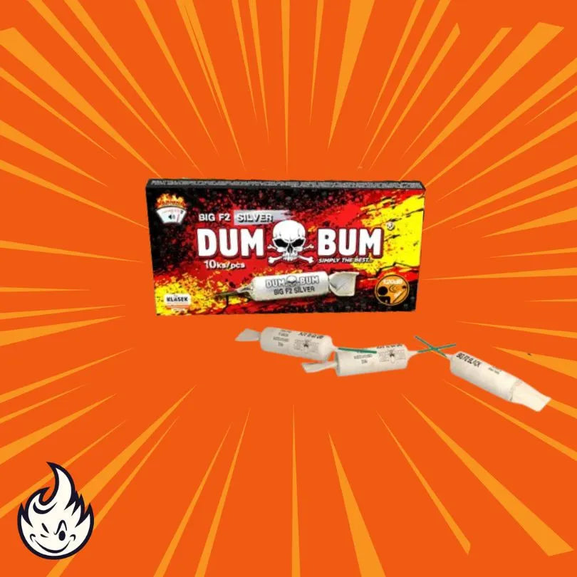 Eine Schachtel mit der Aufschrift "Dumbum Big F2 Black" von Dumbum, mit einer Totenkopfgrafik, ist auf einem orangefarbenen Hintergrund mit geplatzten Linien abgebildet. Davor befinden sich drei zylindrische Feuerwerkskörper, und in der Ecke erscheint ein Cartoon-Flammenlogo.