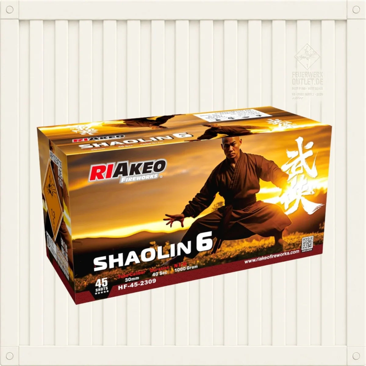Auf einer Schachtel mit „Riakeo Shaolin 6“-Feuerwerkskörpern der Marke RIAkeo ist ein Kampfsportler zu sehen, der vor einem Sonnenuntergang eine Kung-Fu-Pose einnimmt, wobei die Schachtel vor einem weißen, geriffelten Hintergrund platziert ist.